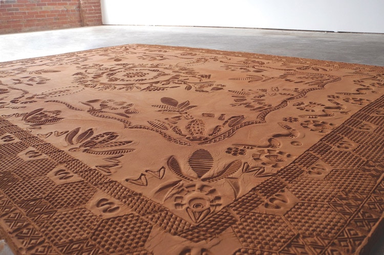 La artista Rena Detrixhe crea alfombras estampadas efímeras de suciedad roja