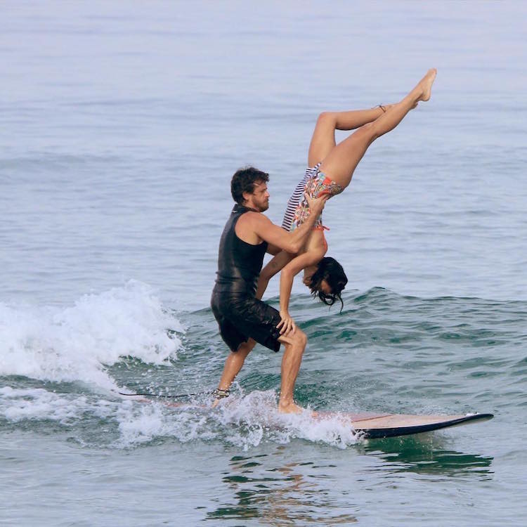 A Couple Shows Tremendous Skill On Shared Surfboard