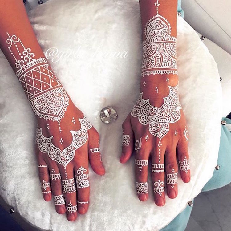 Tender hands of an Indian bride covered with henna tattoo and groom's arm  side by side with wedding rings Stock Photo | Adobe Stock