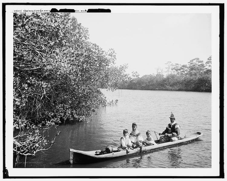 Seminole Indian and family dugout canoe, Miami, Fla.