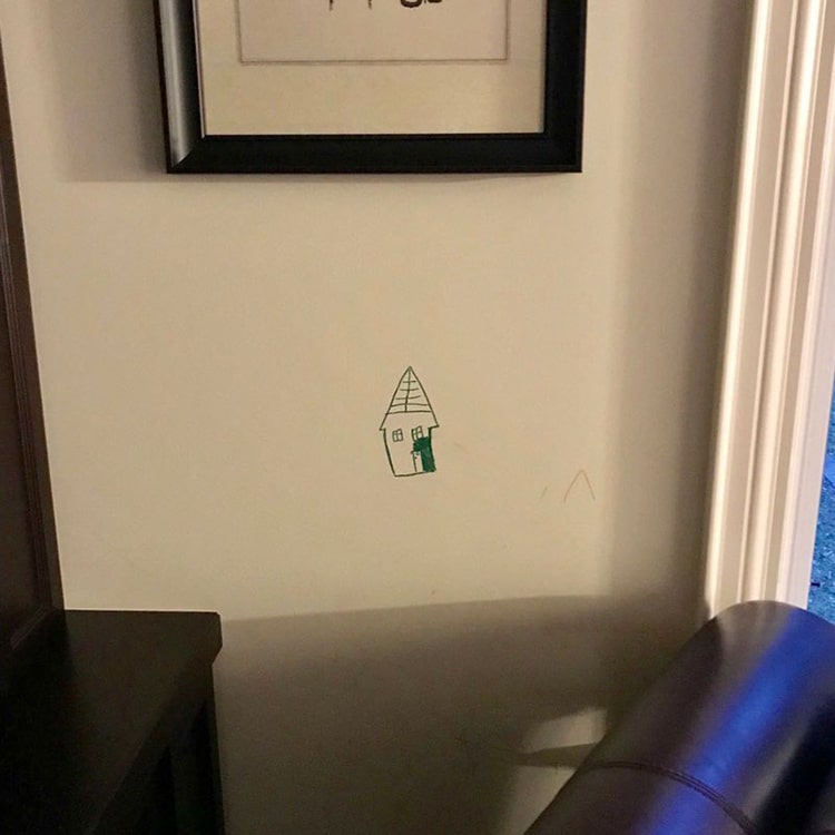 Kids Drawing on Wall Framed by Parents