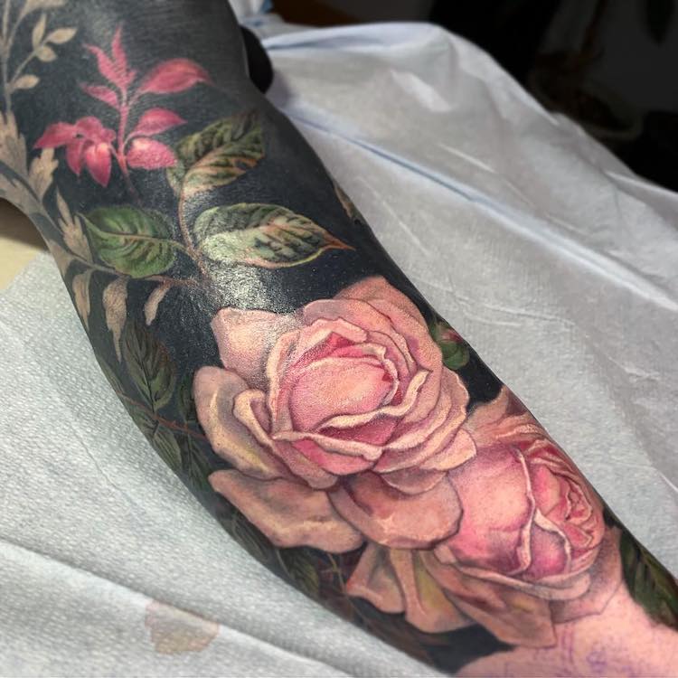 Tatuadora usa tinta negra y flores coloridas para cubrir tatuajes