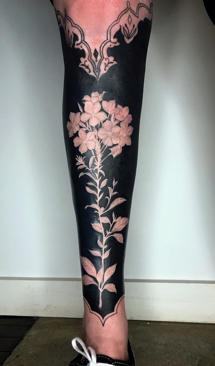 Tatuadora usa tinta negra y flores coloridas para cubrir tatuajes