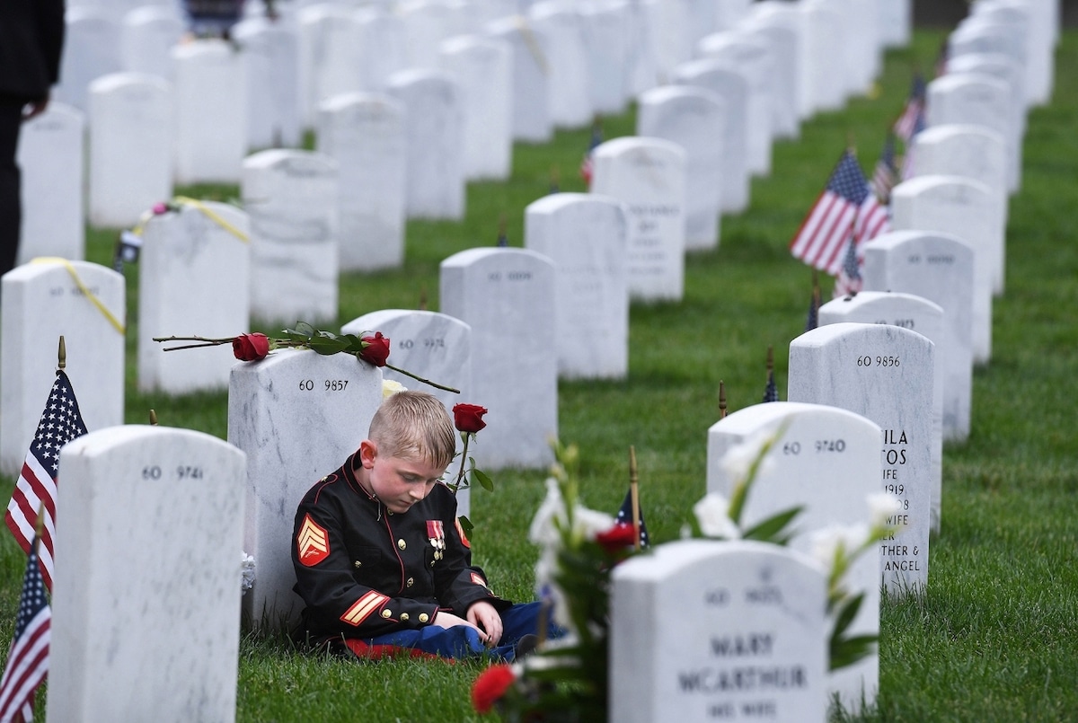 Child Sitting Next to Gravestone