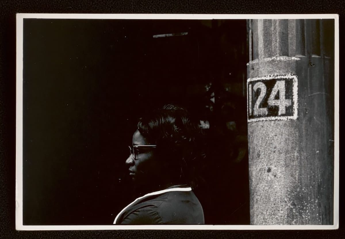 african american woman sitting beside a pole labeled 124