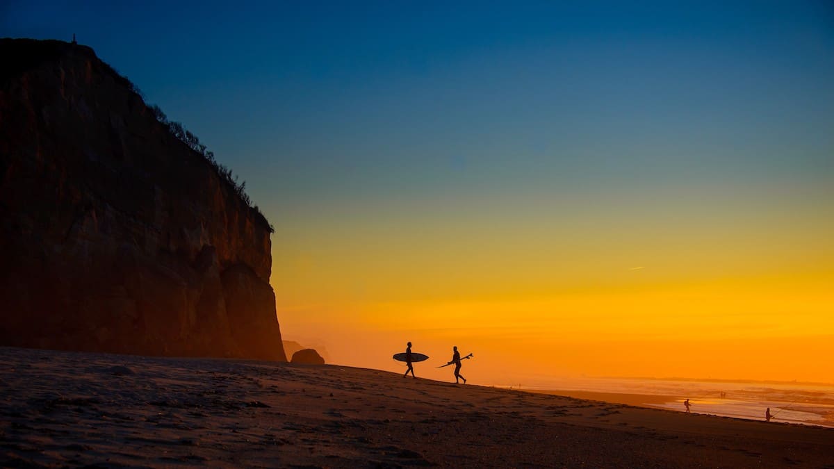 Two Surfers on the Beach at Sunset