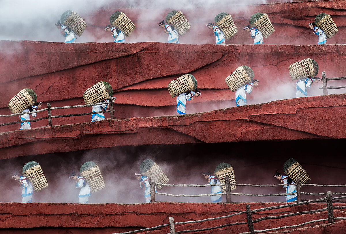 Asian Women Carrying Baskets on their Backs Up a Hill