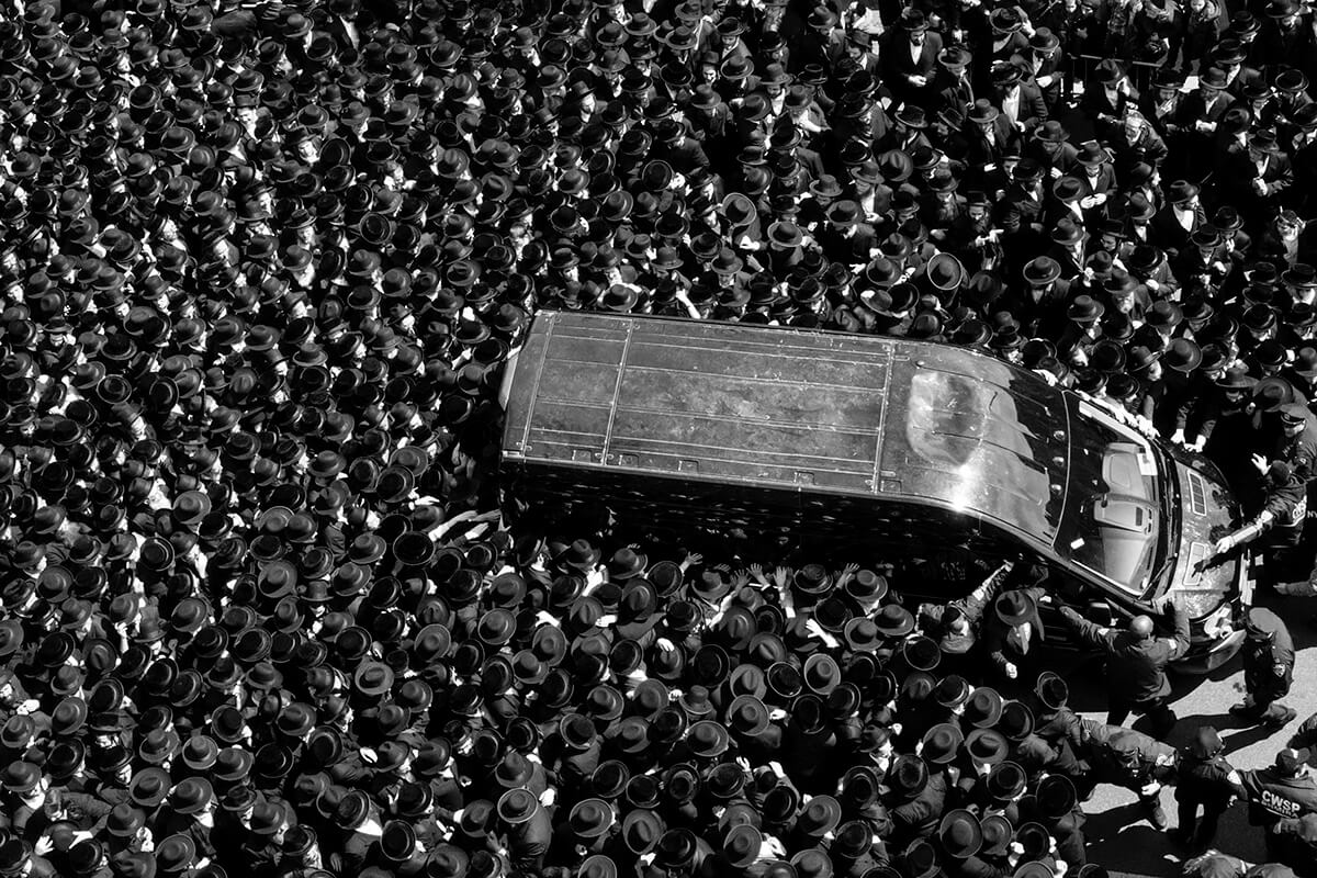 Black and White Photo of Van Swarmed By People in a Crowd