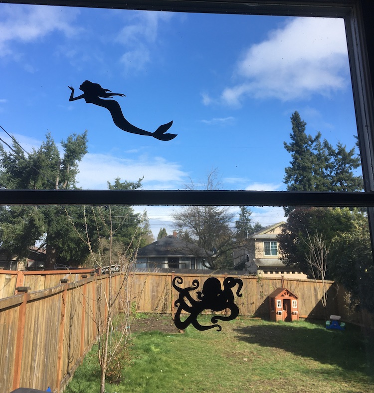 Silueta de una sirena y un pulpo pintada sobre una ventana