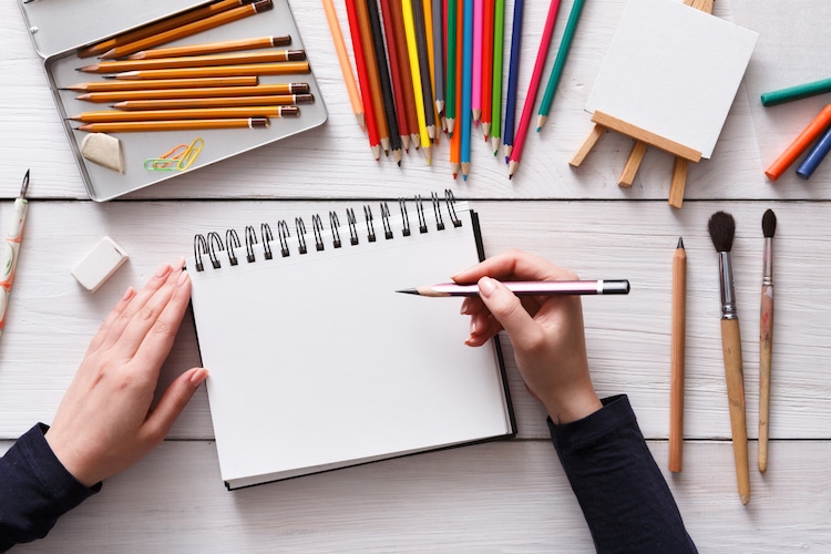 Still life drawing pencils and sketch pad on wood table stock photo