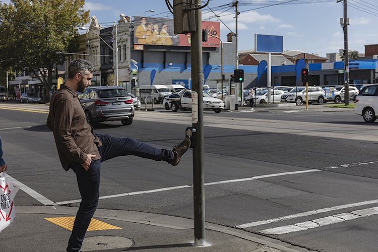 Person Kicking a Pedestrian Crossing Button