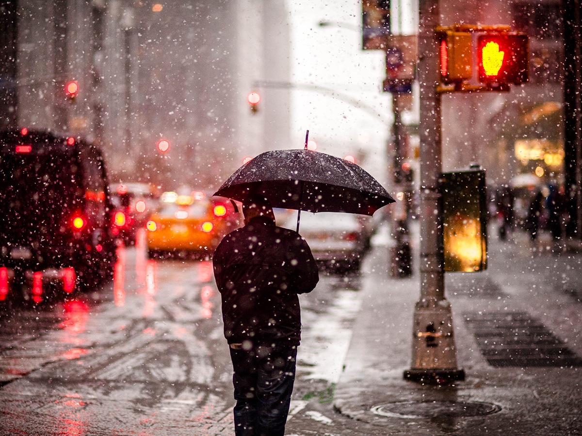 Man with an Umbrella Walking Through Snowstorm in New York
