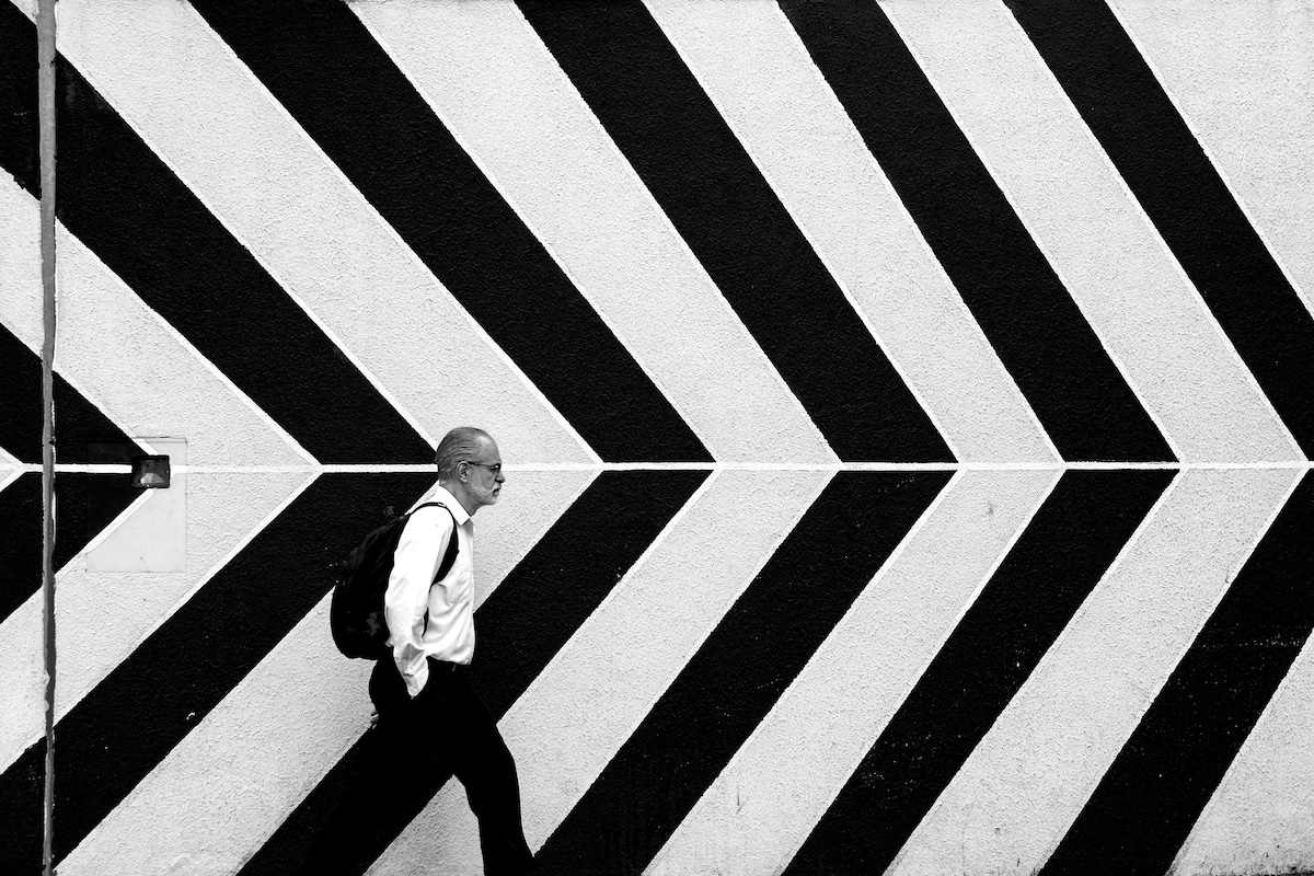 Man Walking past a stripped background