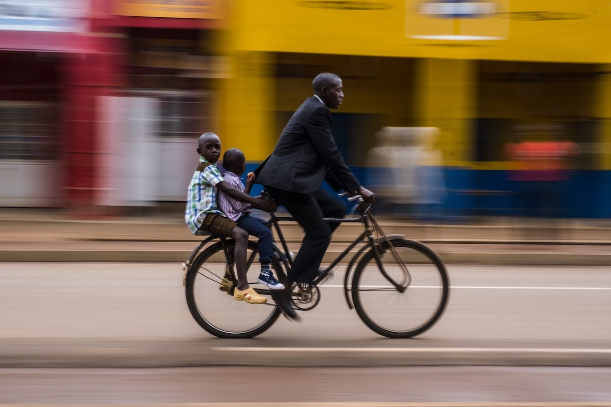 Man Biking with His Children on the Back in Rwanda