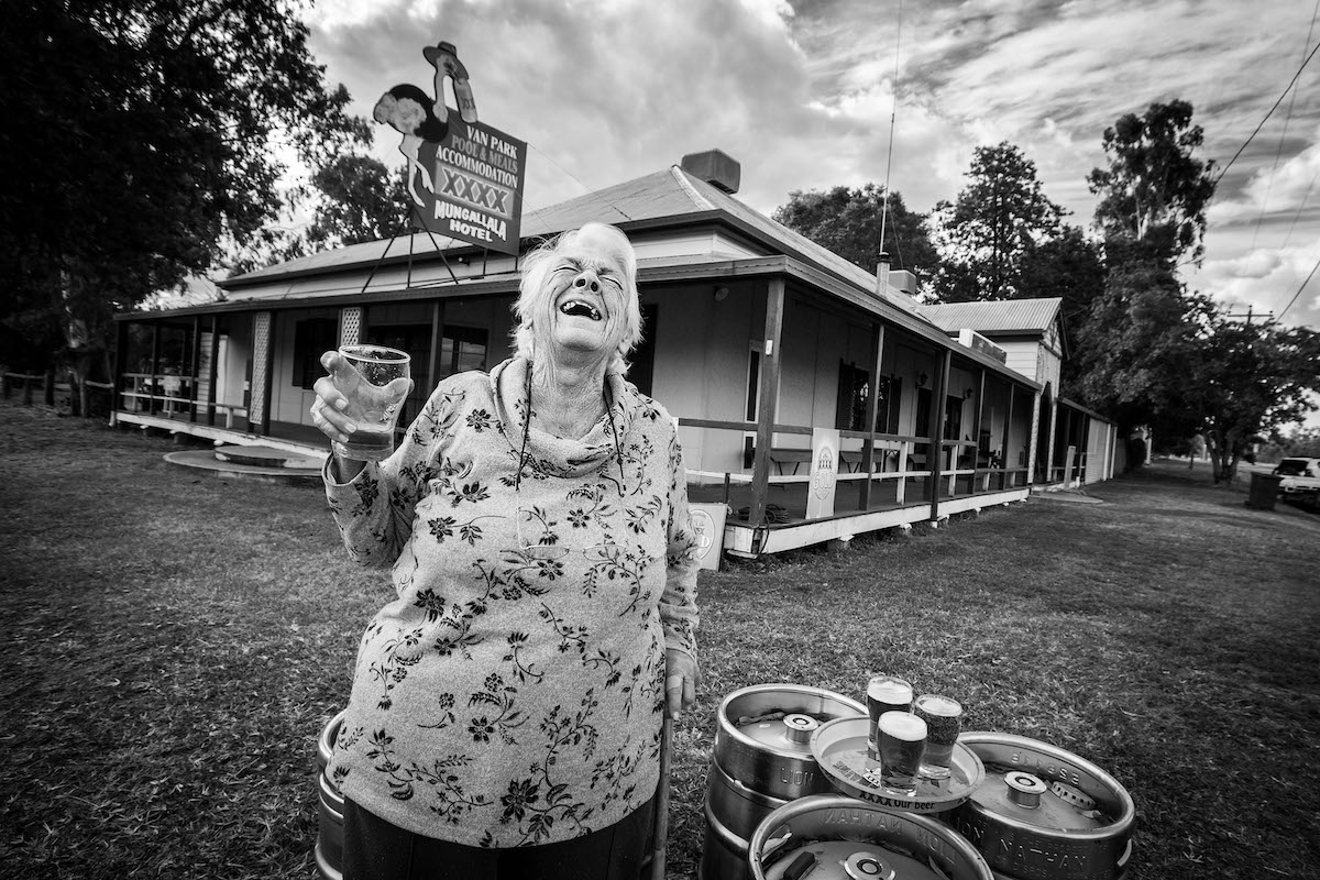 Mujer mayor riendo con una cerveza