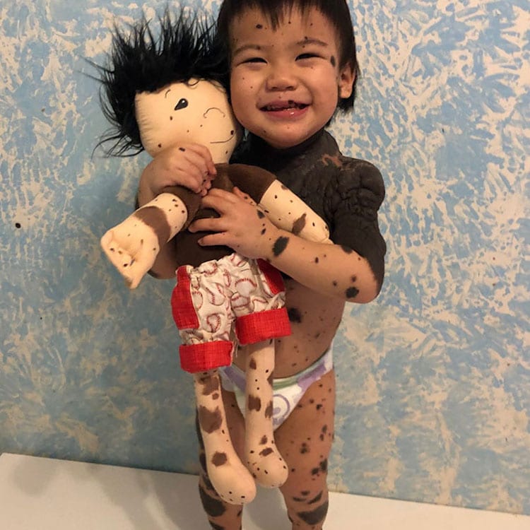 Child Holding a Doll That Looks Like Themselves