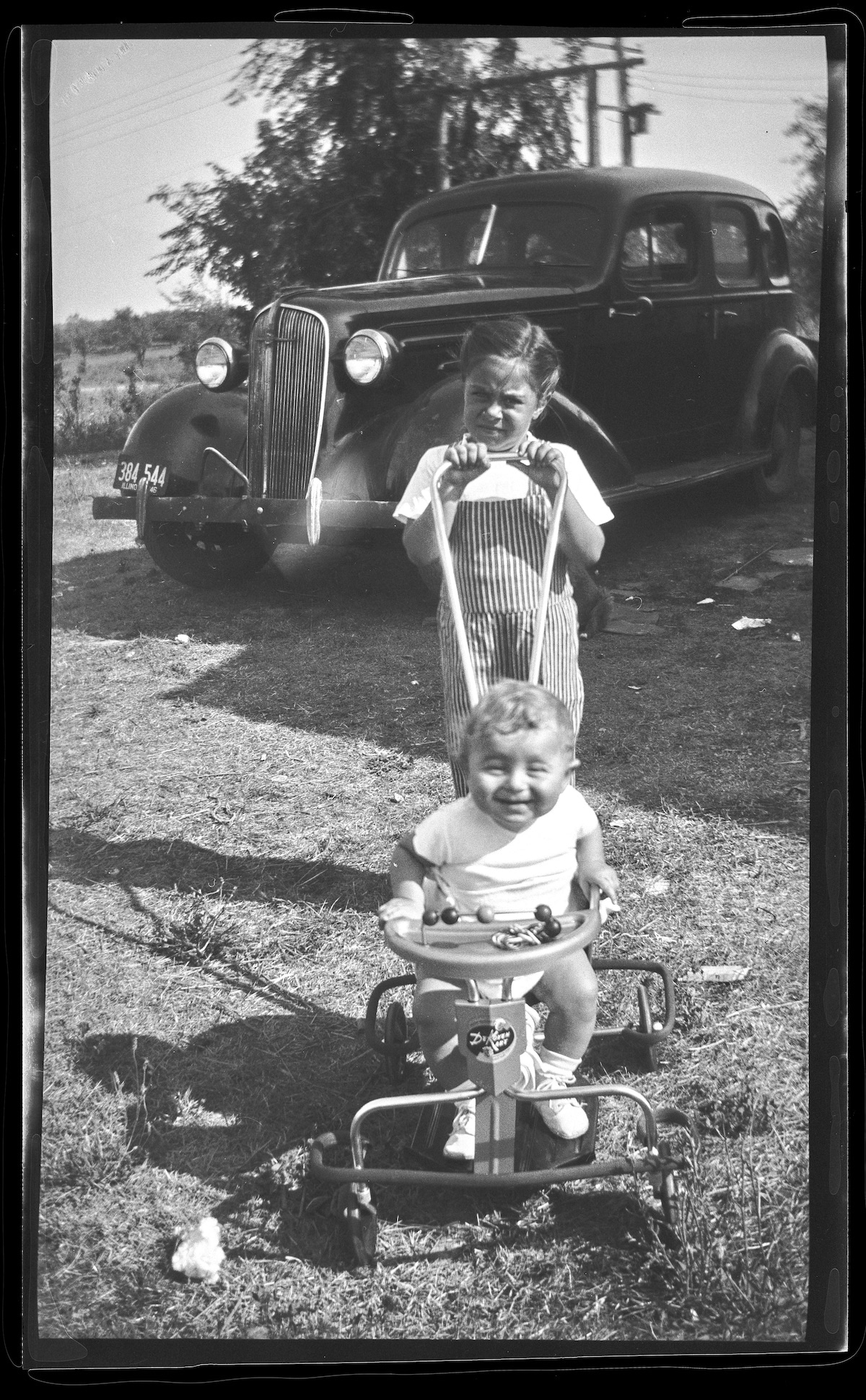 Little Girl Pushing a Boy on a Bike