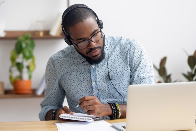 Man Taking Notes During an Online Course