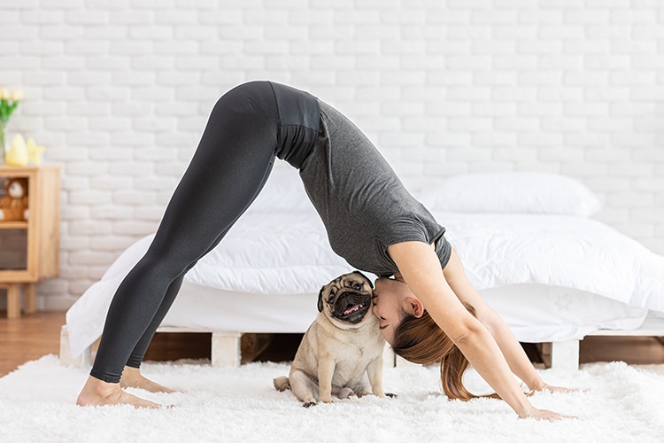 Mujer haciendo yoga con su perro