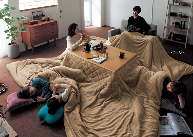 Futón japonés en salón japonés con mesa baja y jarrones en el suelo