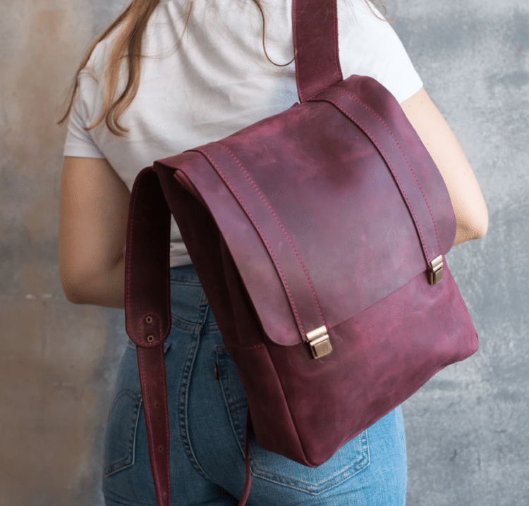 Woman Holding Burgundy Leather Backpack