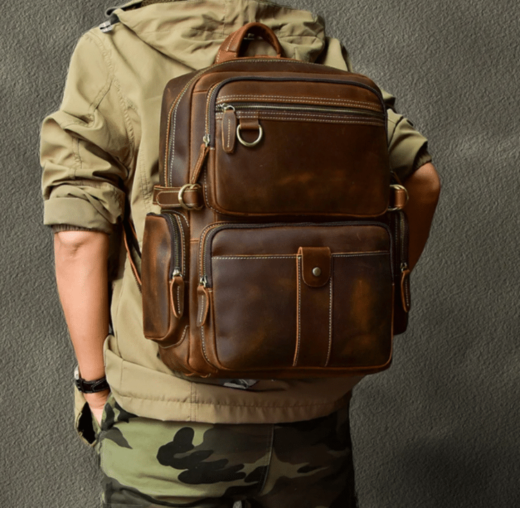 Photo Of Person In Green Hoodie Wearing Dark Brown Vintage Style Leather Backpack