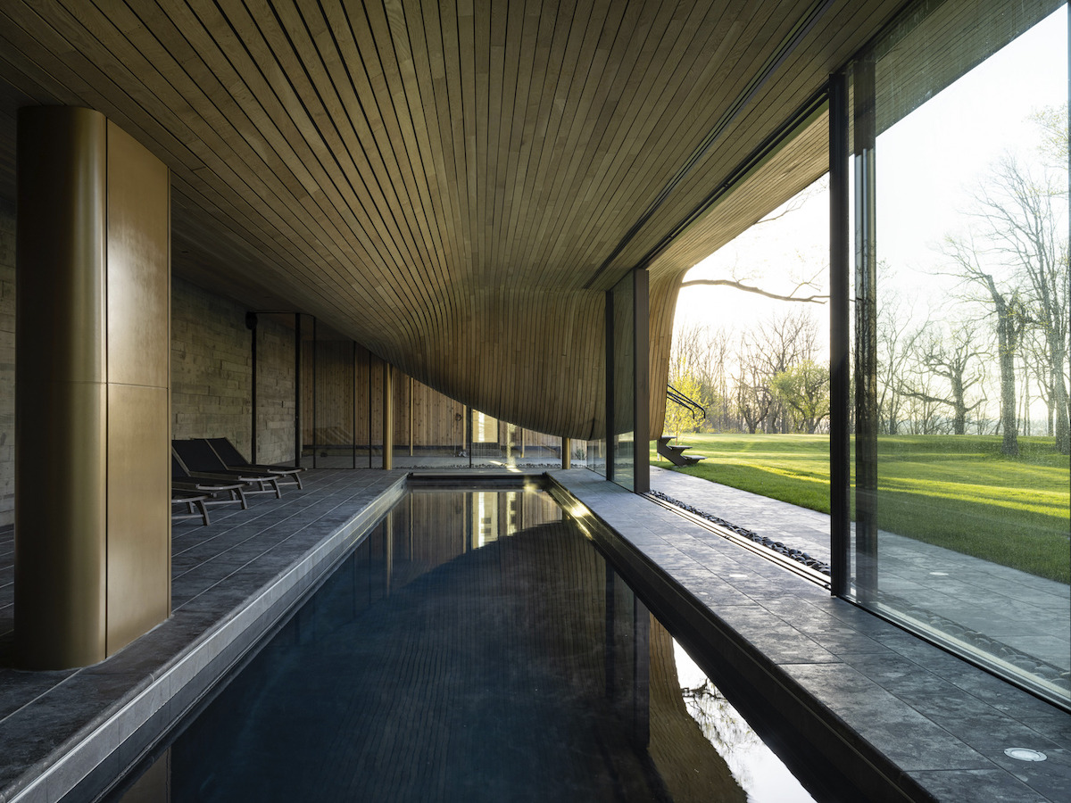 "Fold House" Uses Compression-Bent Wood to Blend into the Hillside