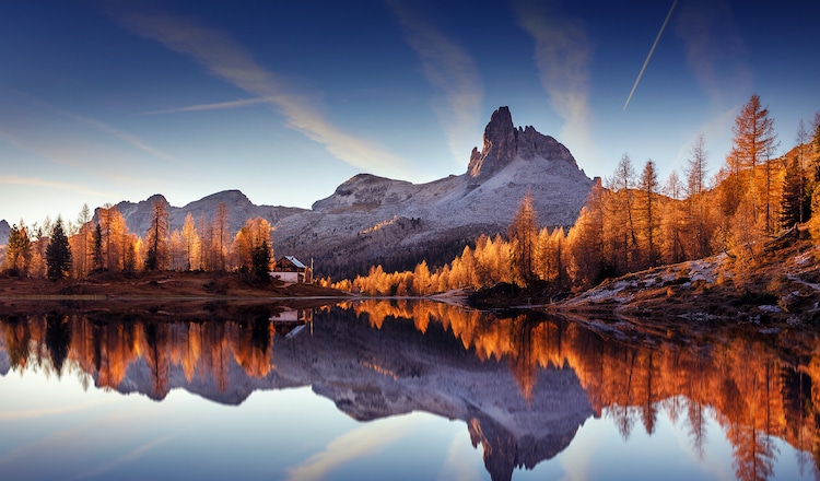 Coucher de soleil au-dessus d'une montagne se reflétant sur un lac