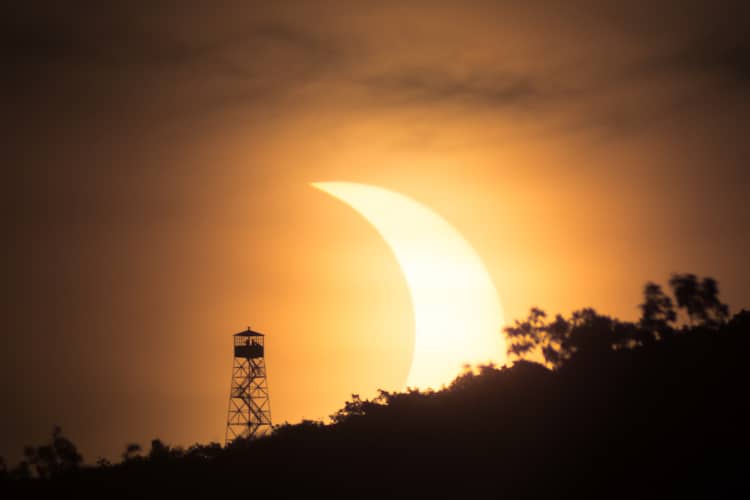 Éclipse solaire à côté d'une tour