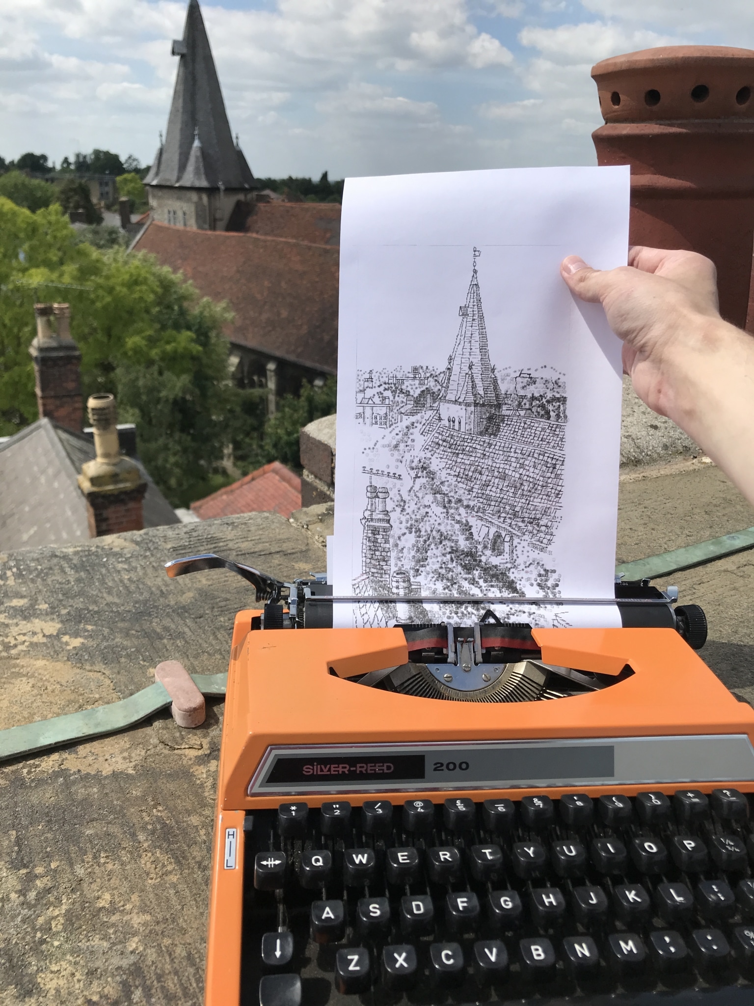 L'artiste James Cook dessine en tapant sur sa machine à écrire