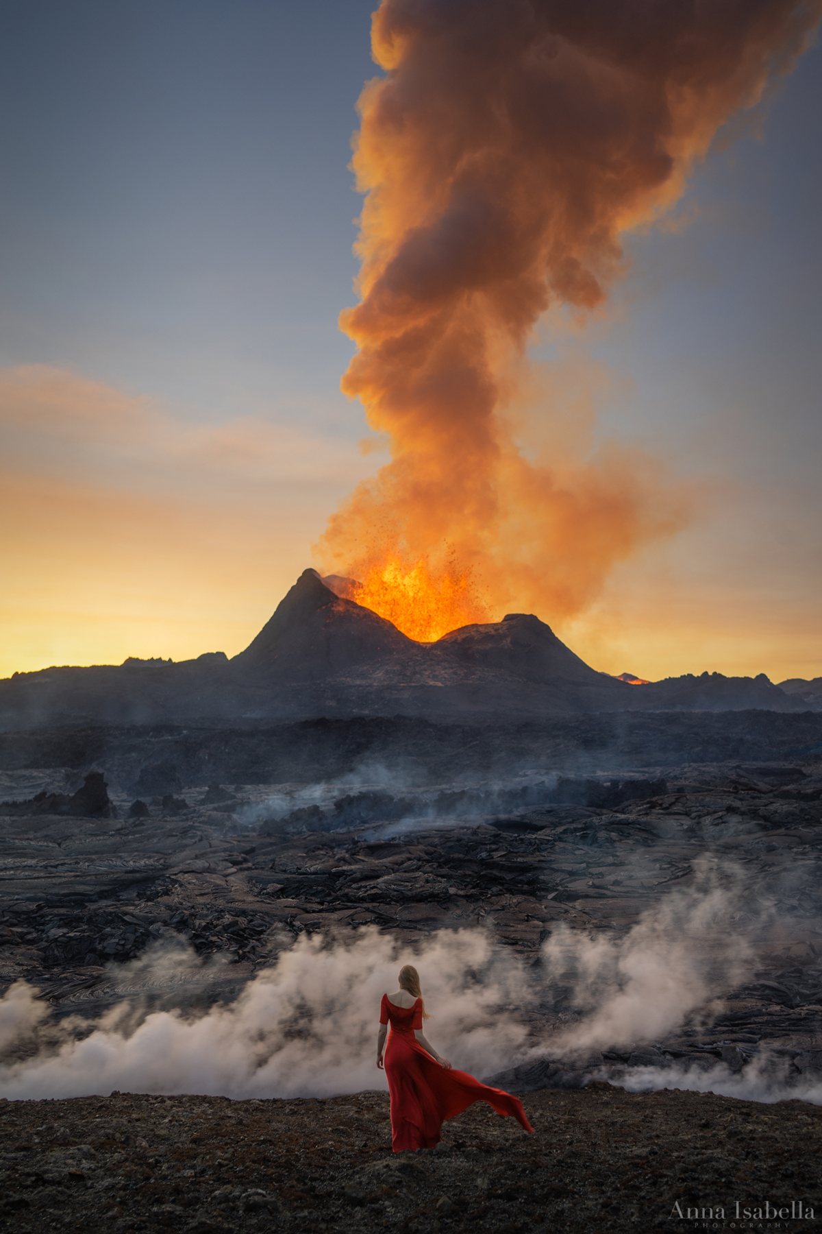 아이슬란드의 Fagradalsfjall 화산 앞에서 포즈를 취하는 빨간 드레스를 입은 여성