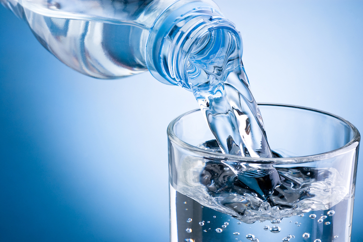 agua de una botella de plástico es servida en un vaso