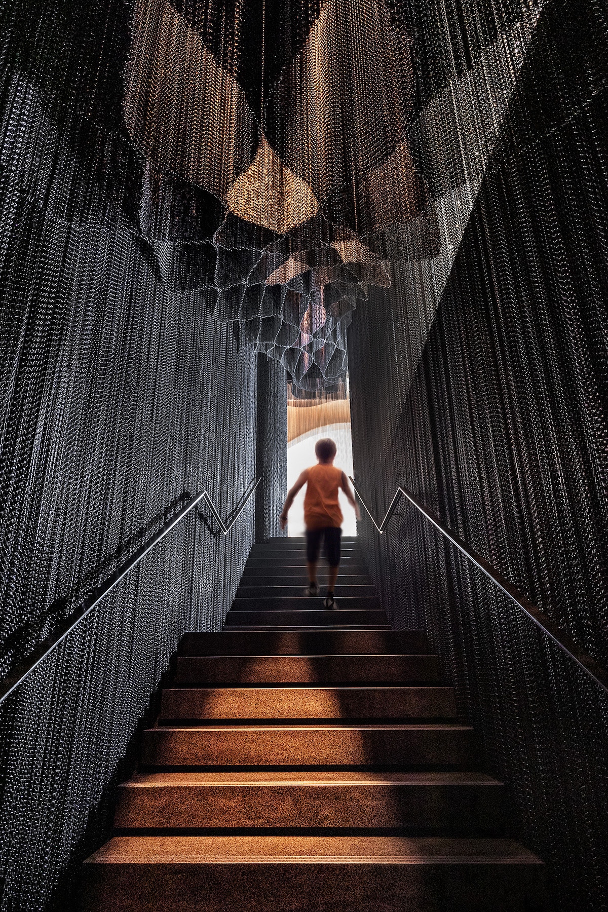 persona pasando por la escalera de cadenas diseñada pr Kengo Kuma para la Casa Batlló de antoni gaudi
