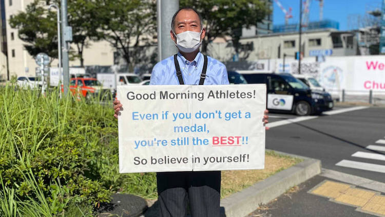 Man Holds Daily Motivational Posters for Athletes at the Tokyo Olympics