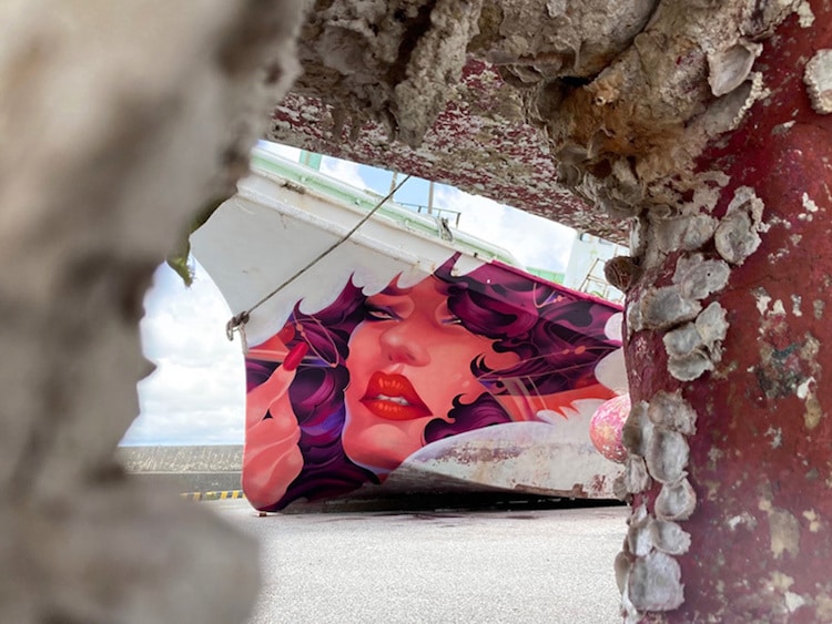 Mural de una mujer pintado en un barco por ONEQ