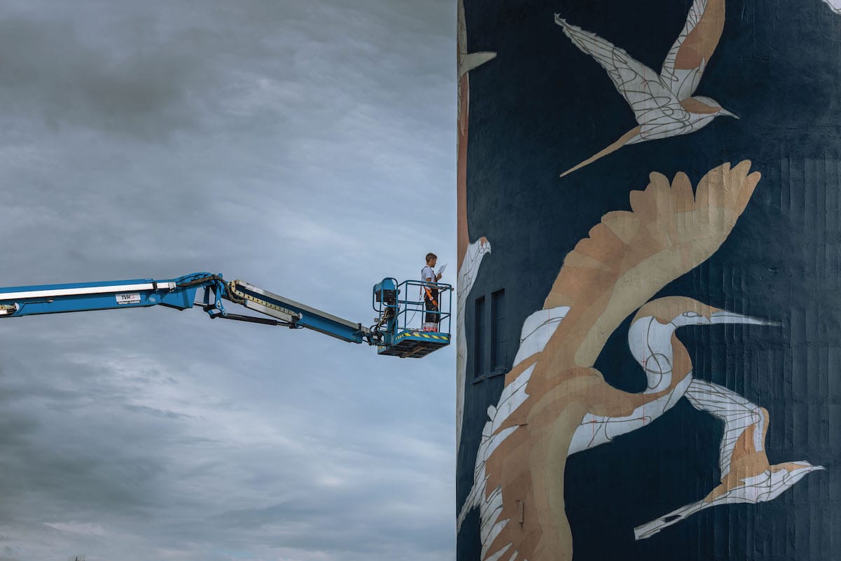 Artiste de rue peignant un château d'eau