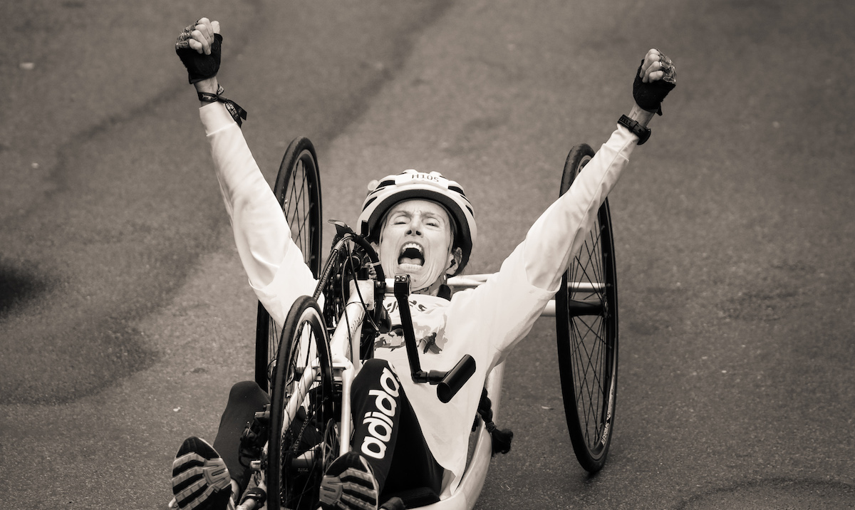 Personne en fauteuil roulant franchissant la ligne d'arrivée du marathon de Boston 2021