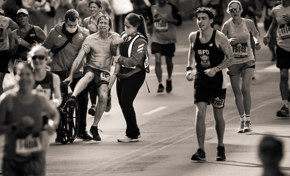Un homme est aidé jusqu'à la ligne d'arrivée du marathon de Boston 2021