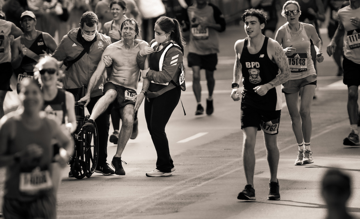 Man Being Helped to the Finish Line of the 2021 Boston Marathon