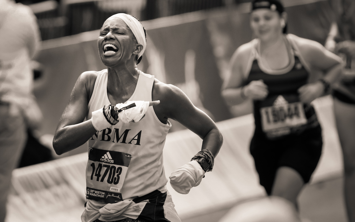 Une femme court vers la ligne d'arrivée du marathon de Boston 2021