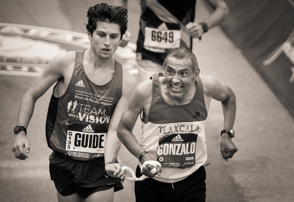 Hommes en course vers la ligne d'arrivée du marathon de Boston 2021