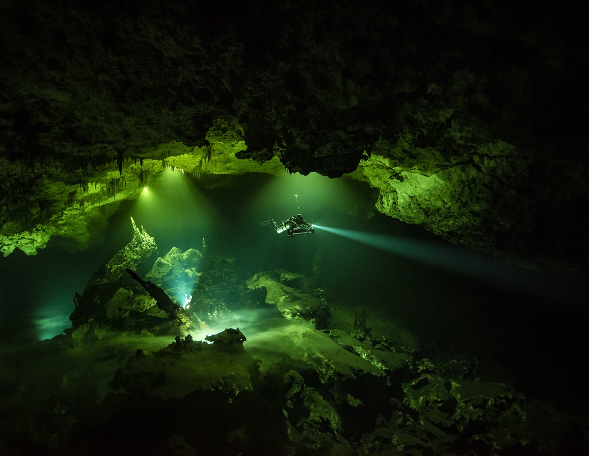 Diver Swimming Through Underwater Cave in Mexico