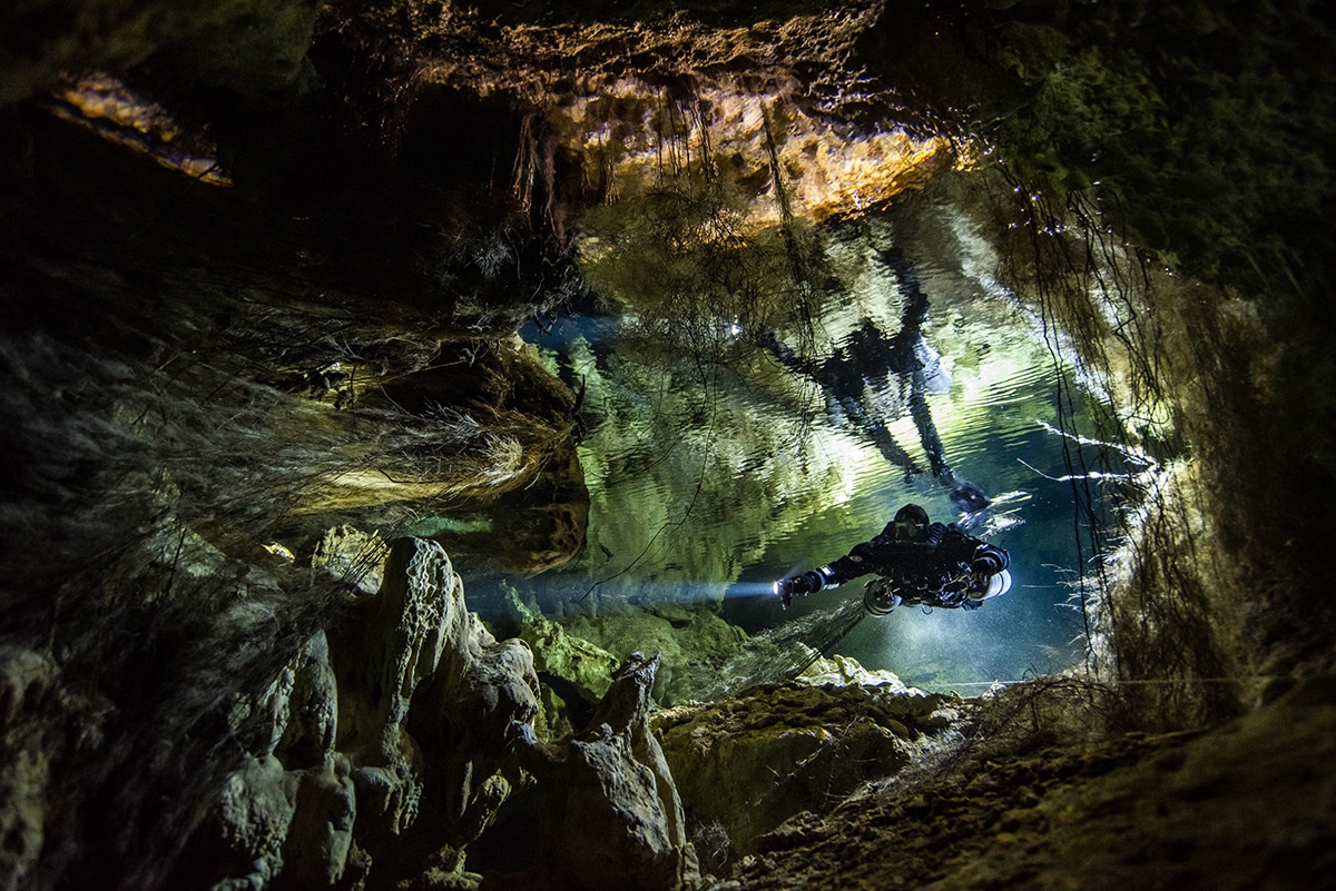 Diver Swimming Through Underwater Cave in Mexico