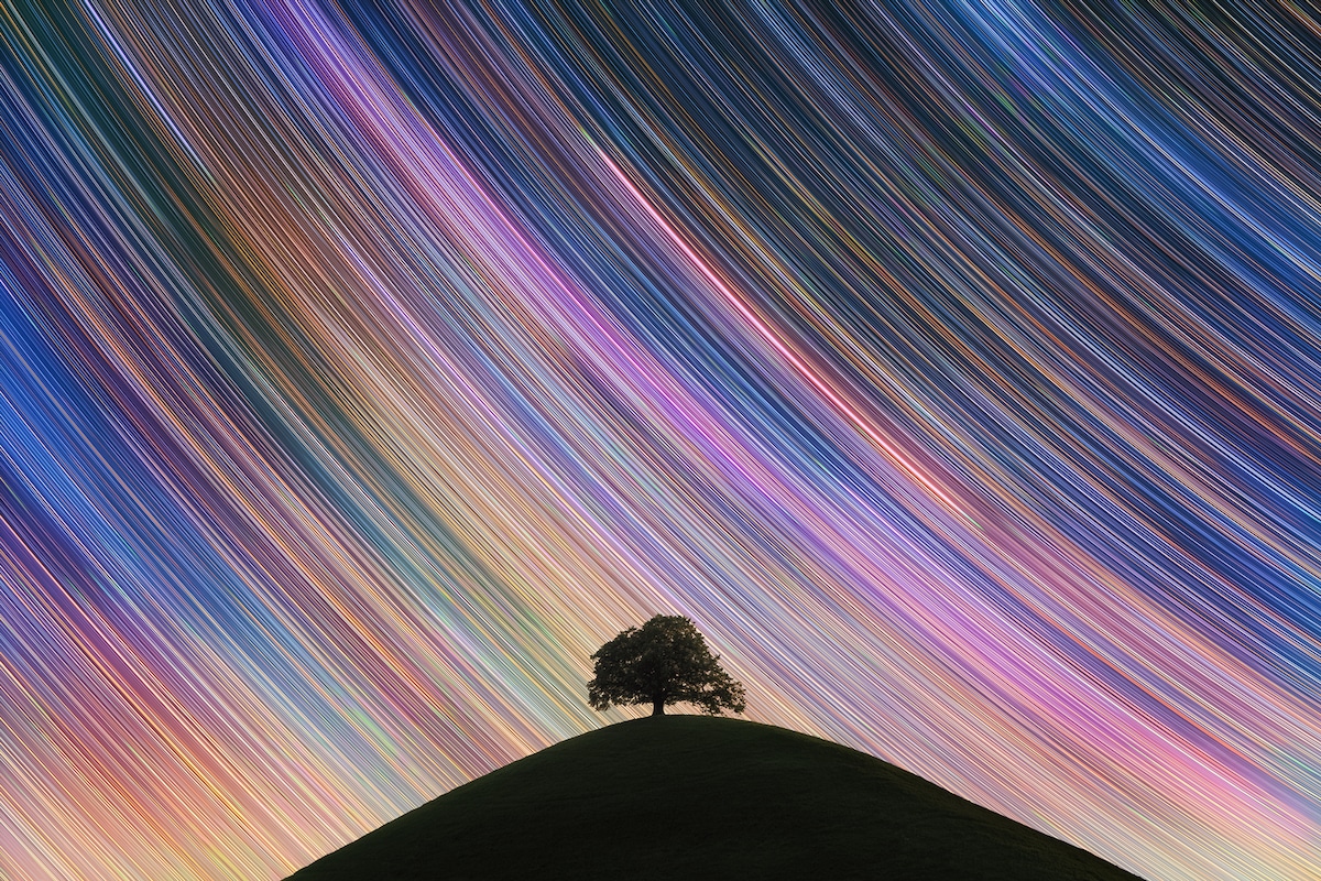 Colorful Star Trails Over a Hill