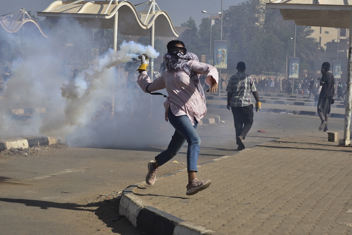 Protester in Sudan Throwing Tear-Gas Canister