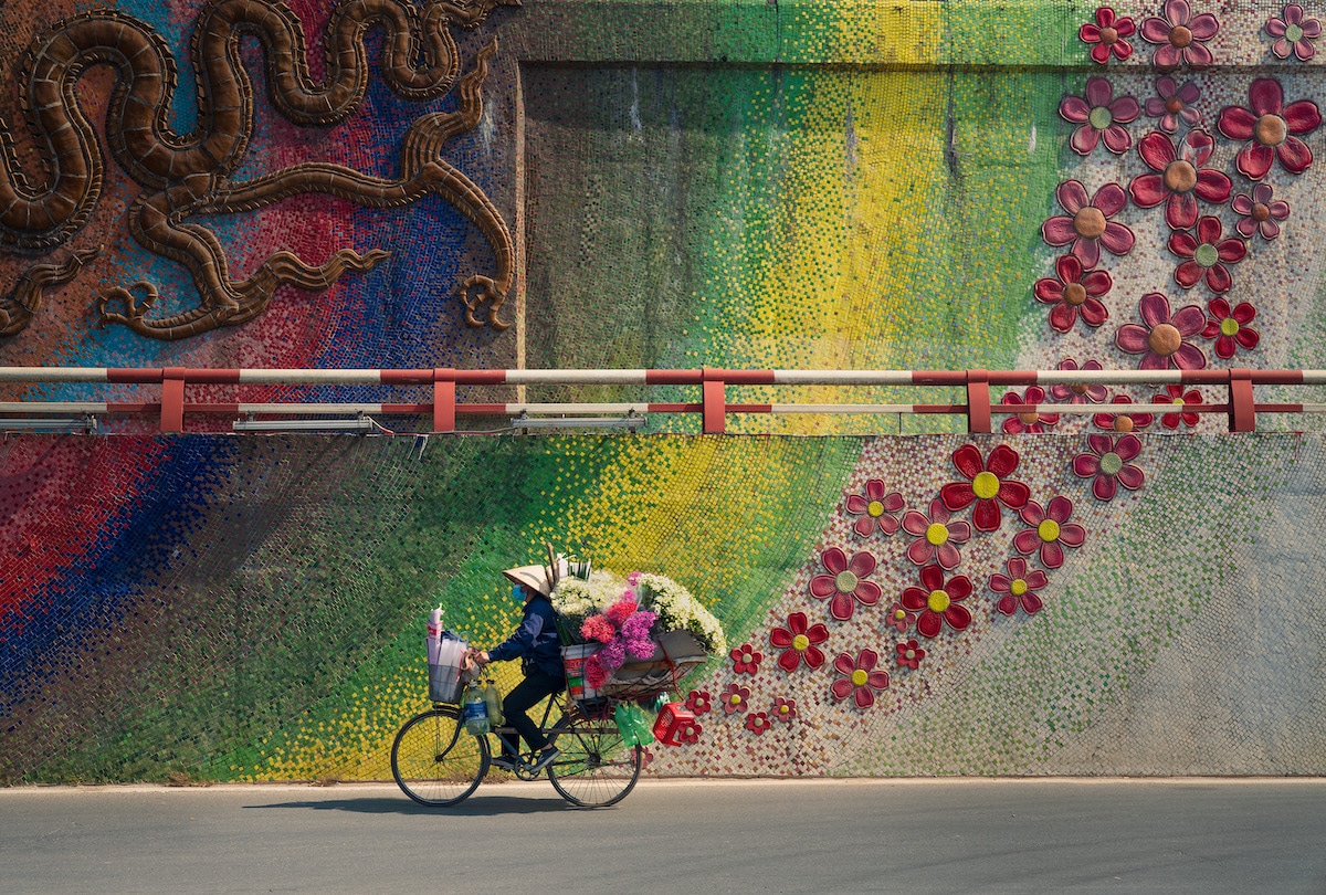 화려한 벽 앞에서 하노이의 자전거를 탄 노점상