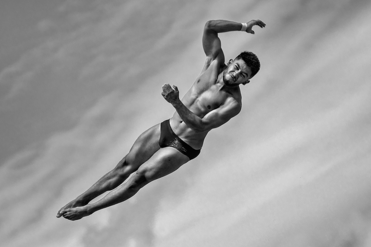 Black and White Photo of a Diver Jumping Off a Platform