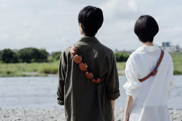 Two Friends Each Wearing the Skipping Stone Bag Across their Shoulder