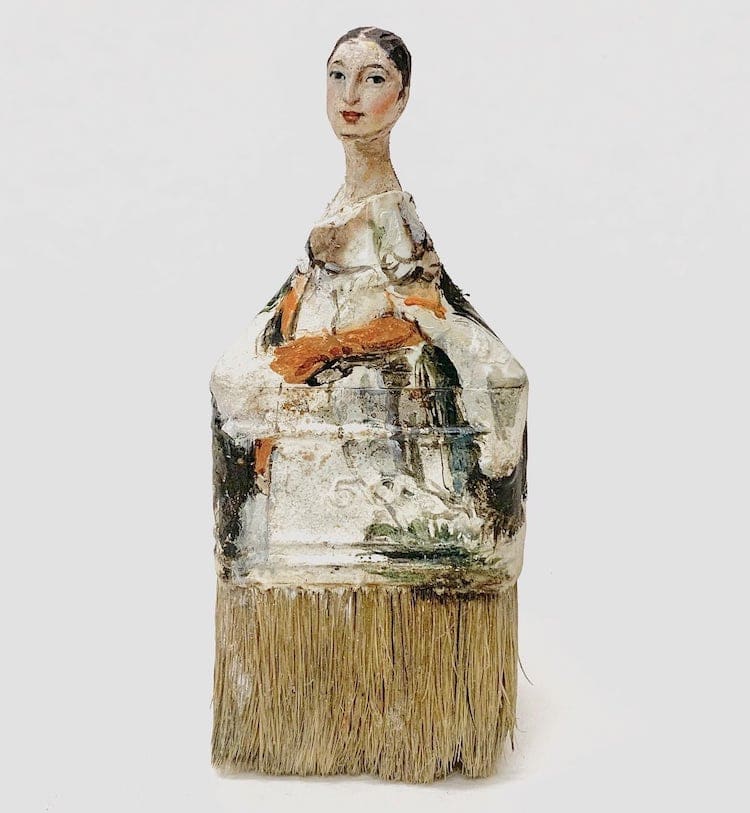 Photo of an old paintbrush painted to look like a woman in a dress