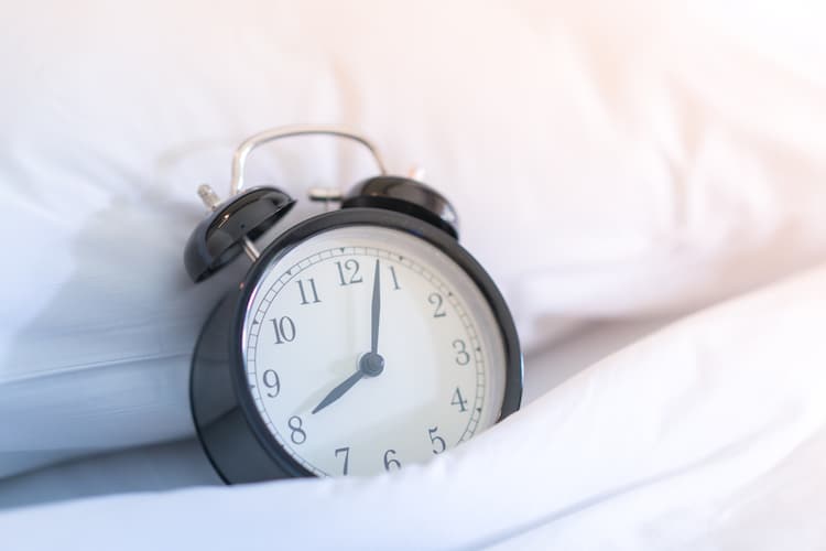 Vintage Alarm Clock on a Bed